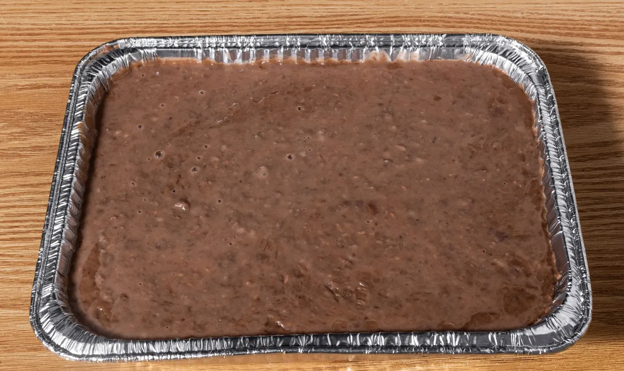 Large tray of fresh-cooked pinto beans, ready for catering service