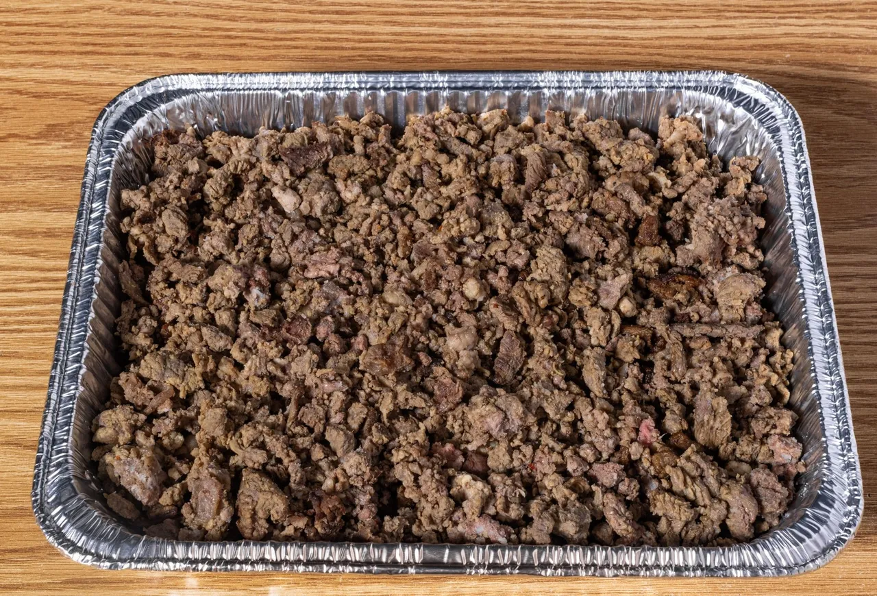 Large tray of slow-simmered seasoned meat, ready for catering service